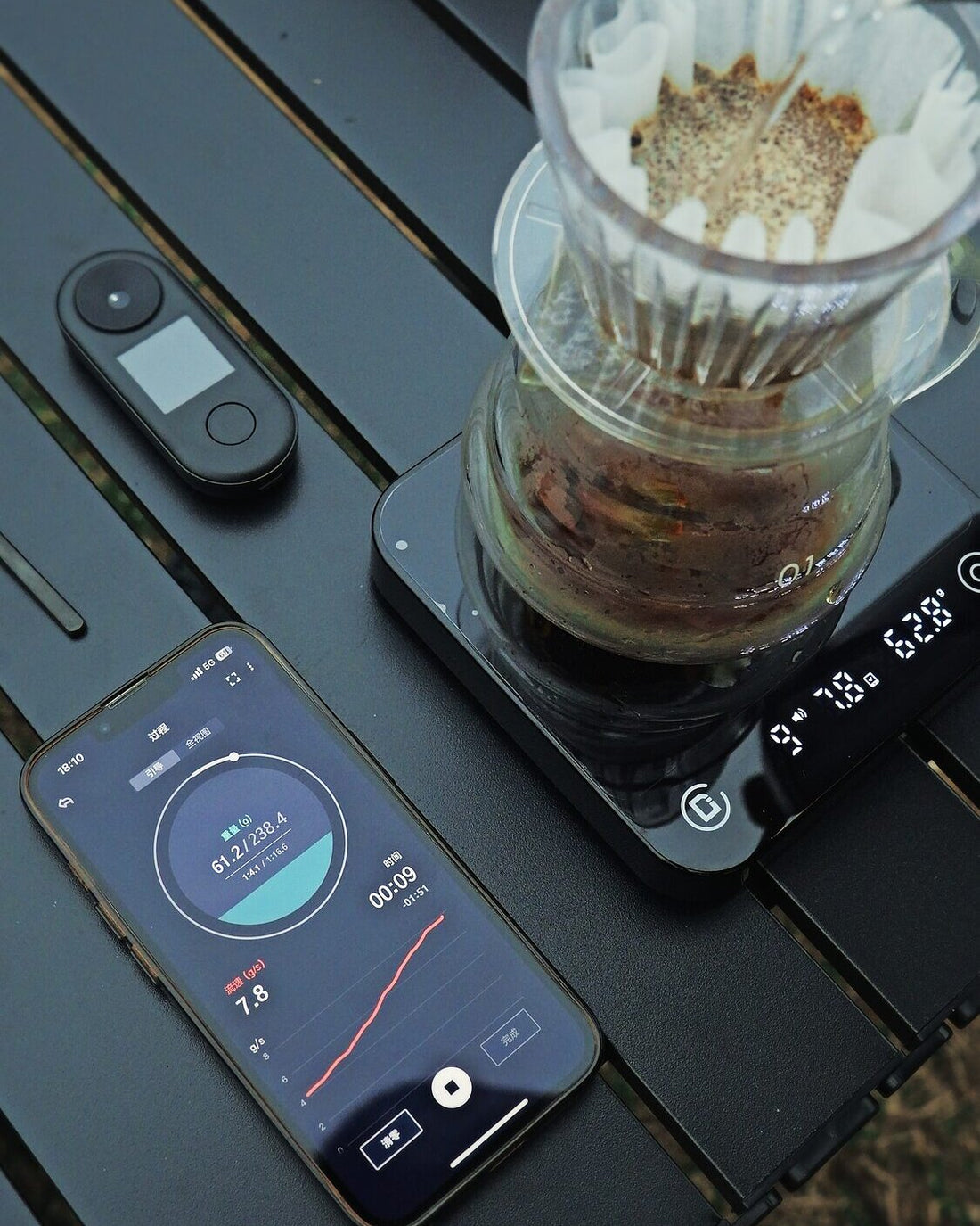 A pour-over brewing on Microbalance, with R2 Extract and CoffeeOS beside it