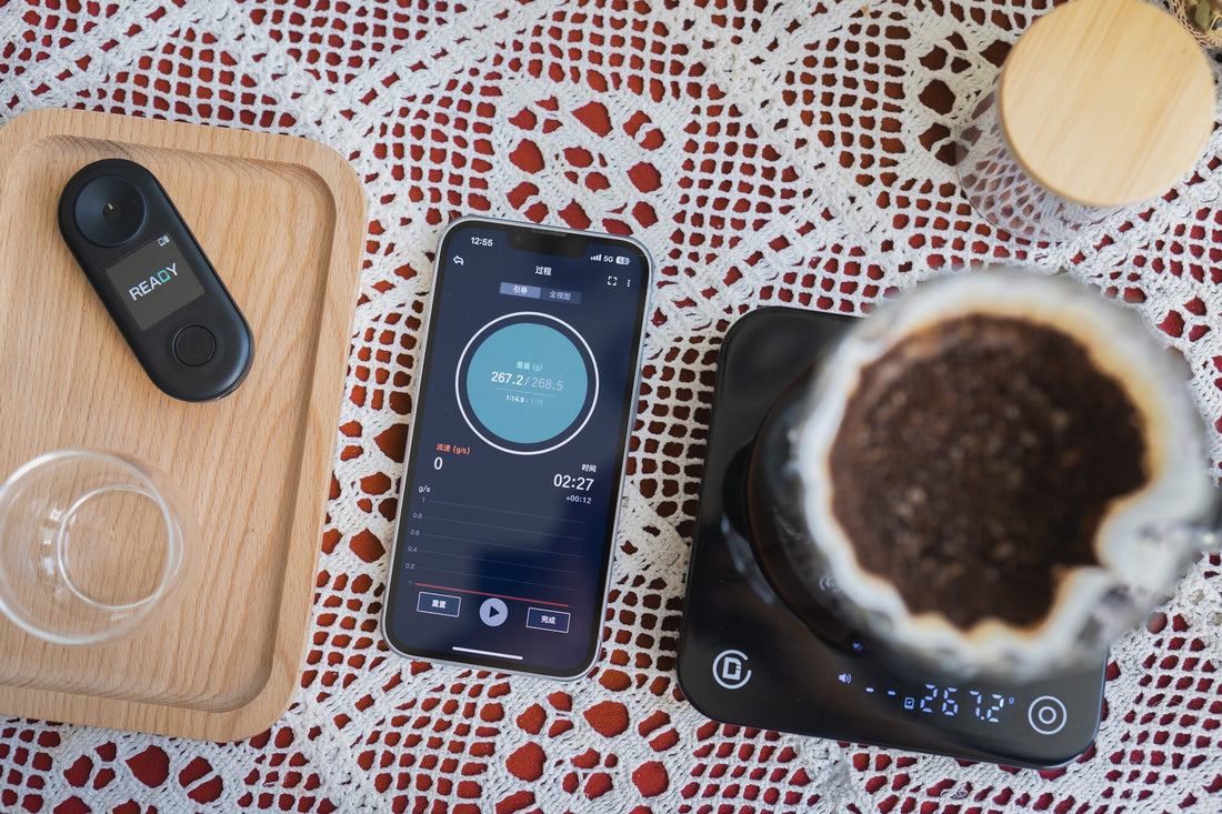R2 Extract beside a phone running CoffeeOS and a pour-over on a scale