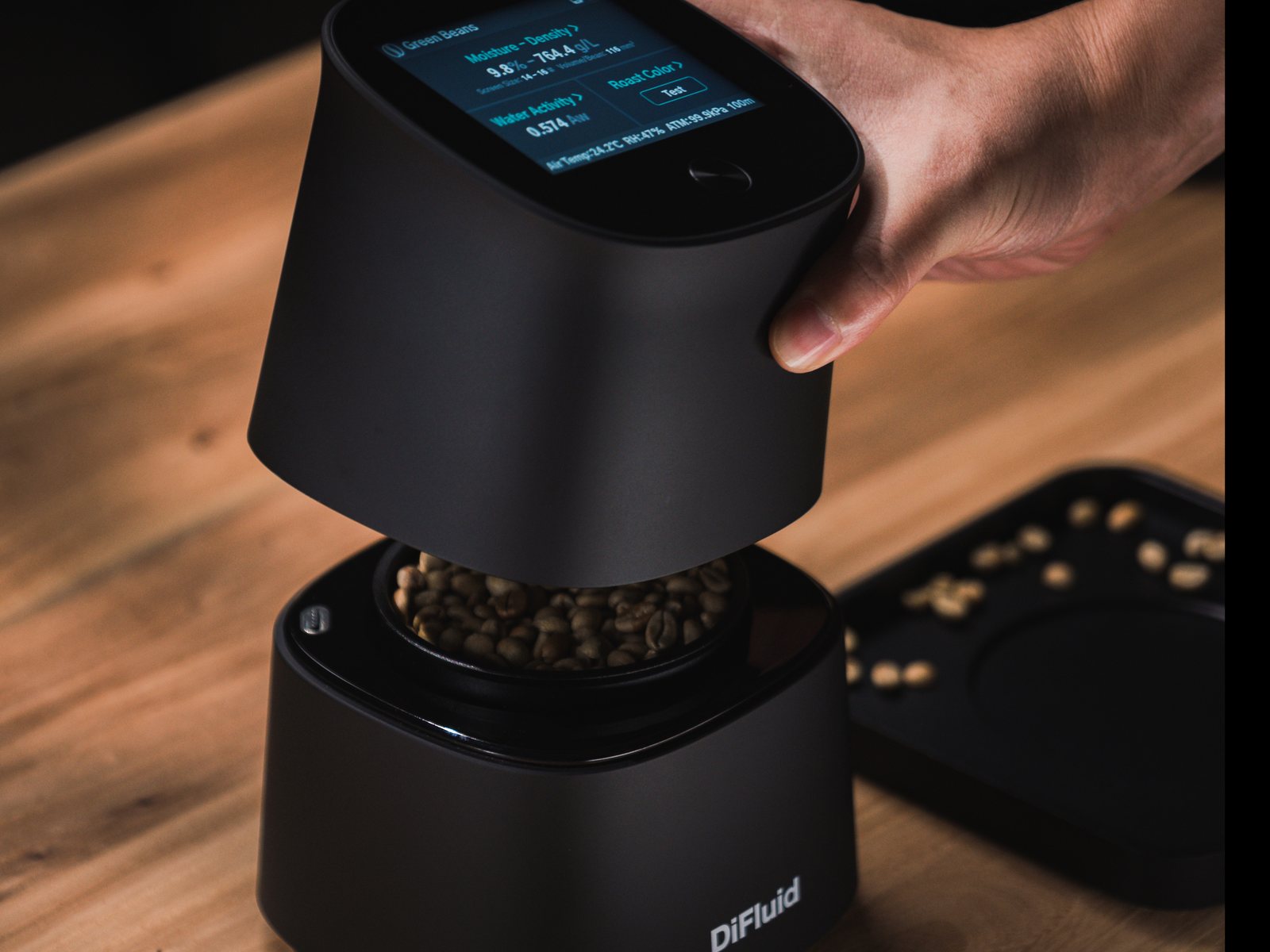 DiFluid Omix Plus cerrándose sobre un recipiente con café verde para realizar una medición de densidad