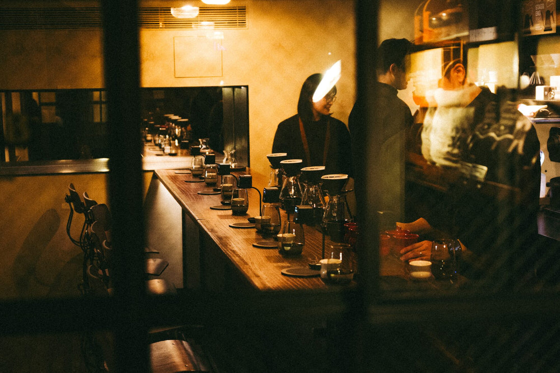 A coffee bar at night, lined with brews and Moment devices